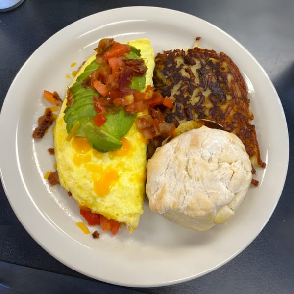 A Shakers American Café breakfast plate with an omelet, hash browns, and a biscuit.