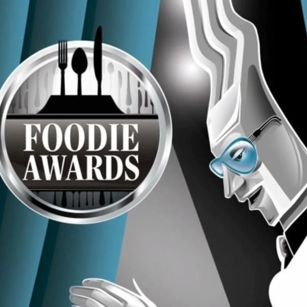 Foodie Awards logo with fork, spoon, and knife, next to a chef character.